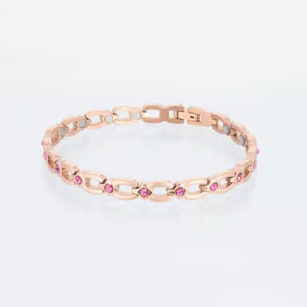 Ein rosegoldenes Magnetarmband, matt gebürstet, mit glänzenden Zwischenteilen, die jeweils einen pinkfarbenen Zirkoniastein enthalten