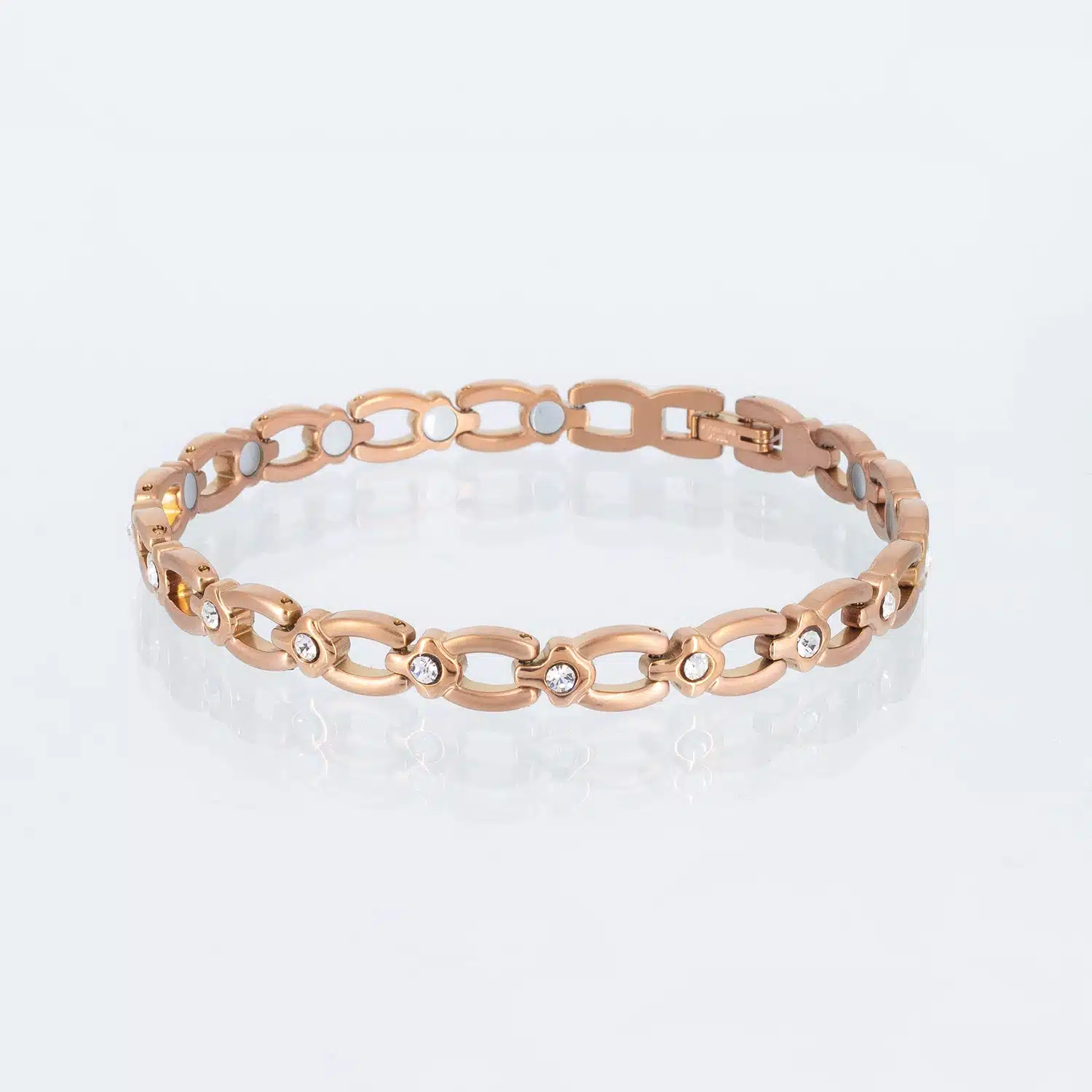 Ein rosegoldenes Magnetarmband, matt gebürstet, mit glänzenden Zwischenteilen, die jeweils einen weißen Zirkoniastein enthalten