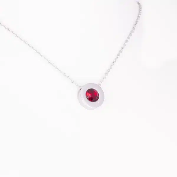 Ein Magnetanhänger mit einem dunkelroten Zirkoniastein und Kette