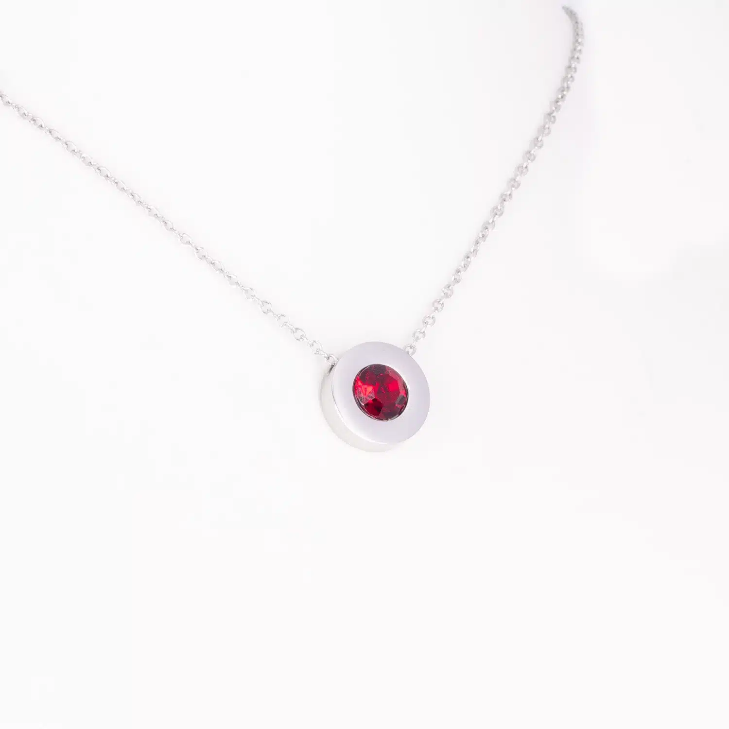Ein Magnetanhänger mit einem dunkelroten Zirkoniastein und Kette