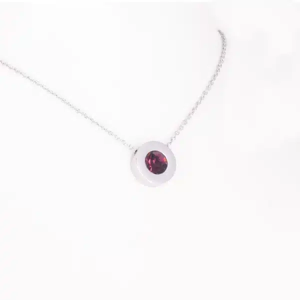 Ein Magnetanhänger mit einem auberginefarbenen Zirkoniastein und Kette
