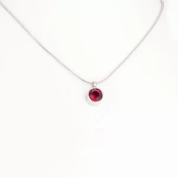 Ein Magnetanhänger mit einem dunkelroten Zirkoniastein und Kette