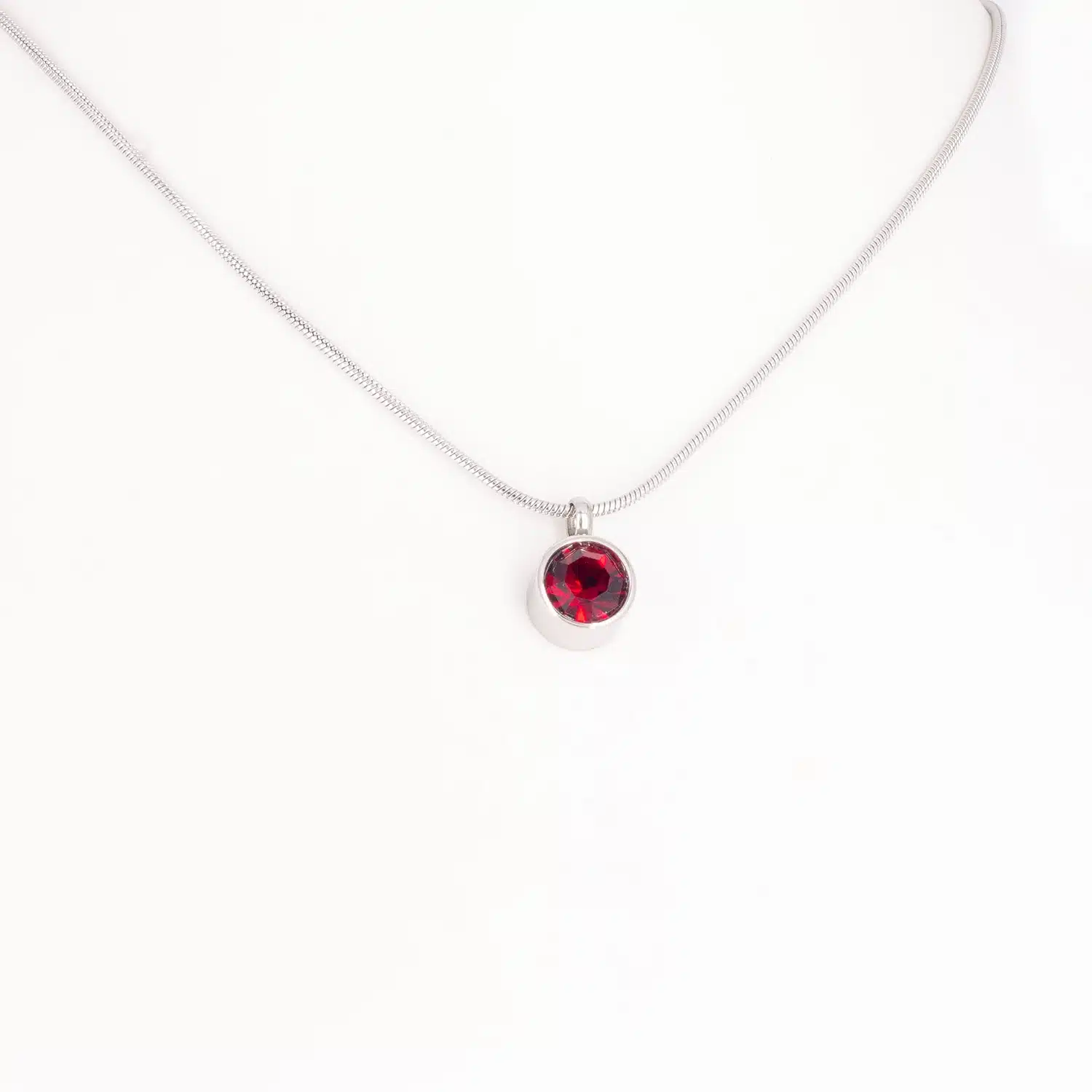 Ein Magnetanhänger mit einem dunkelroten Zirkoniastein und Kette