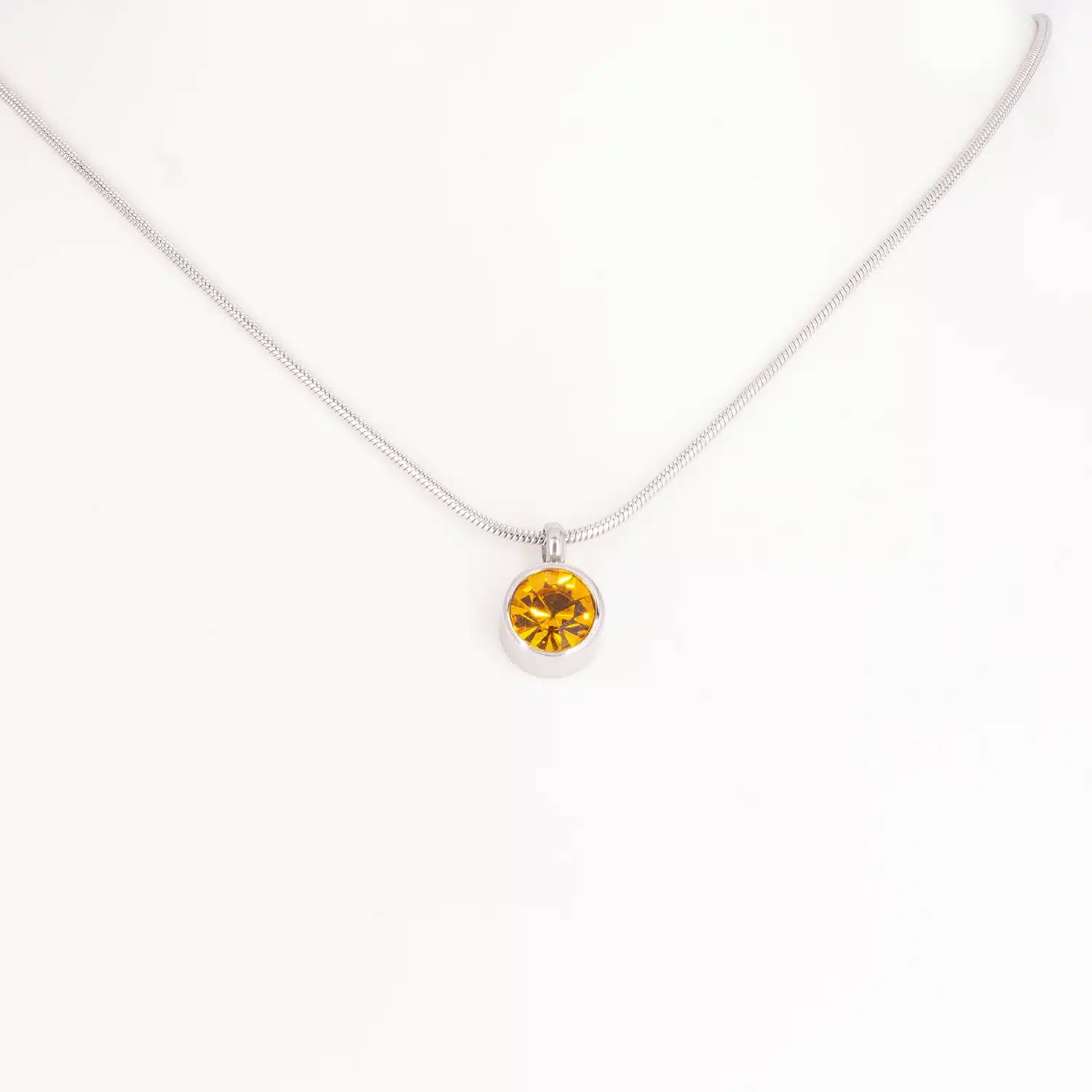 Ein Magnetanhänger mit einem bernsteinfarbenen Zirkoniastein und Kette
