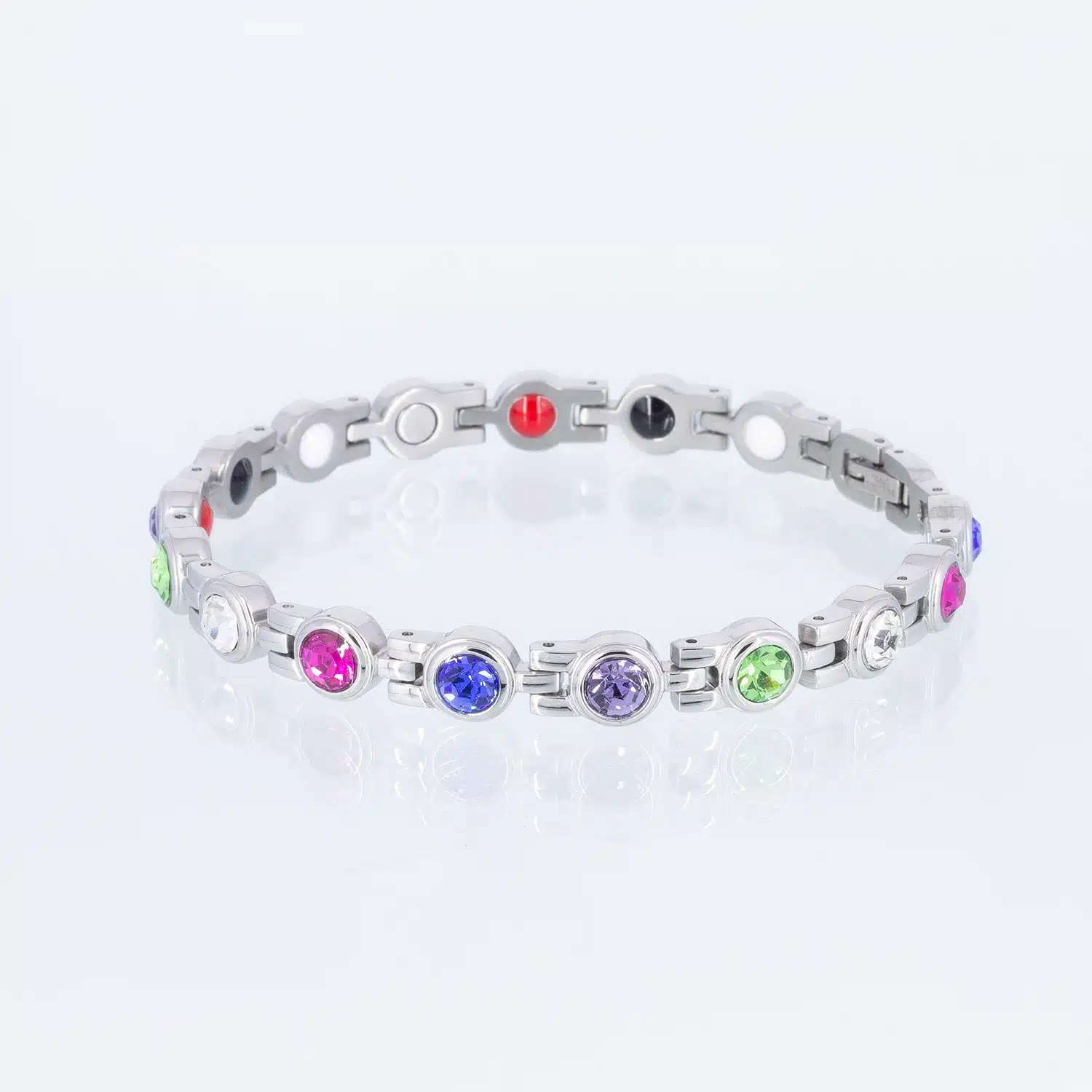 Ein silbernes Magnetarmband mit Zirkoniasteinen in den Farben weiß, grün, rosa, lila und brombeer