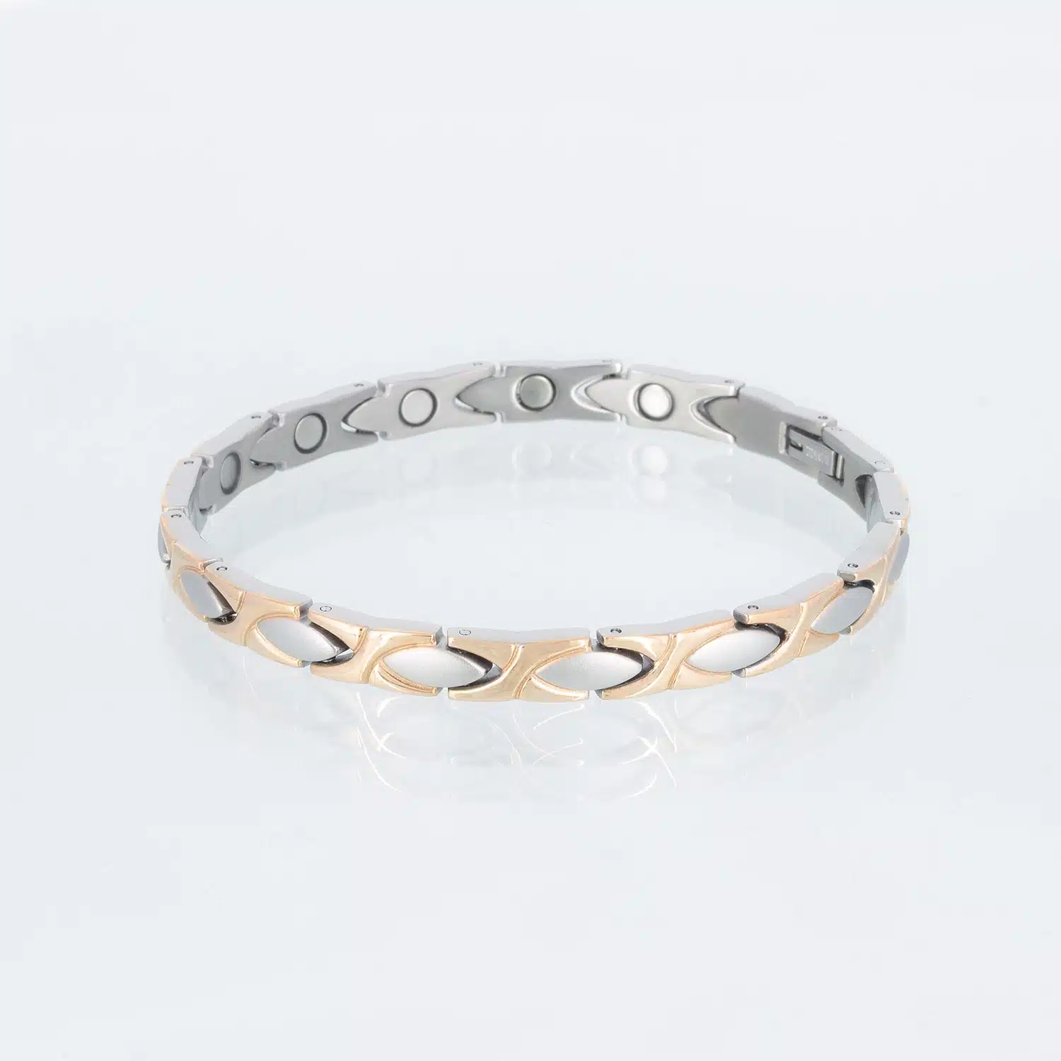 Ein Magnetarmband aus Titan mit mattierten Ellipsen und glänzenden Zwischenteilen. Diese haben eine rosegoldene Ionenplattierung