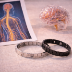 Zwei Magnetarmbänder liegen auf einer Tischfläche neben einer anatomischen Darstellung des Nervensystems
